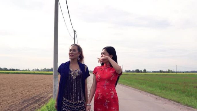 两个亚洲女孩在稻田边说边走