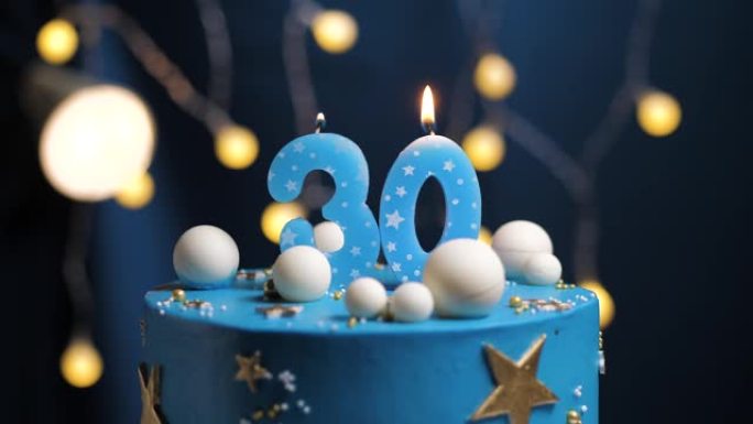 生日蛋糕编号30星星天空和月亮概念，蓝色蜡烛被打火机点燃，然后吹灭。如果需要，请在屏幕右侧复制空间。