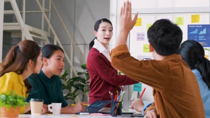 亚洲ux开发人员和ui设计师在现代办公会议上向老板询问有关白板上移动应用程序界面设计的问题。创意数字