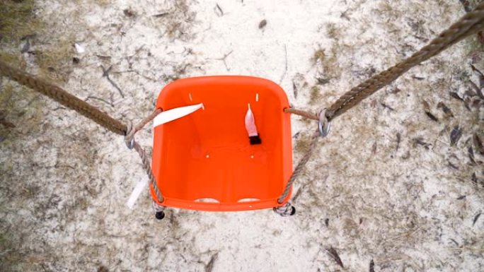 爱沙尼亚操场上的一把橙色秋千椅