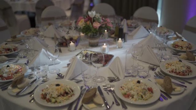 婚礼上的大桌子上的饭菜，鲜花和蜡烛