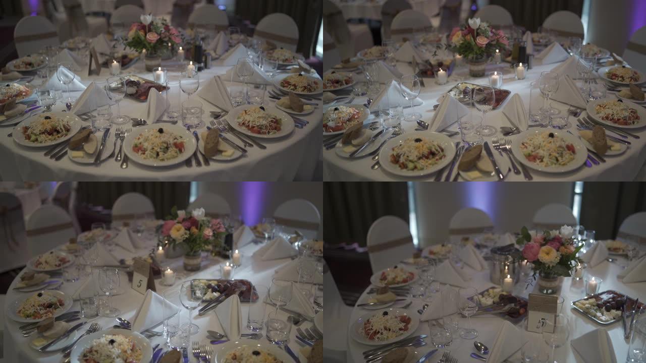 婚礼上的大桌子上的饭菜，鲜花和蜡烛