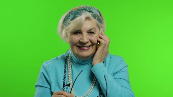 老年时尚的高加索祖母女人在手机上聊天。色度键