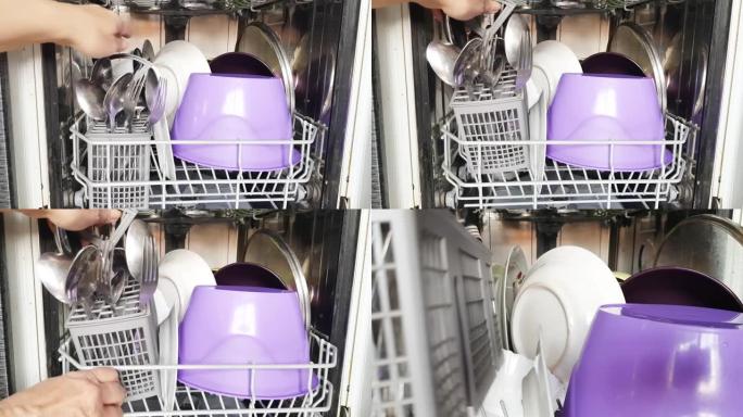 家庭主妇使用现代洗碗机，将脏盘子放在洗碗机中，特写镜头。家用现代家用电器。4k视频
