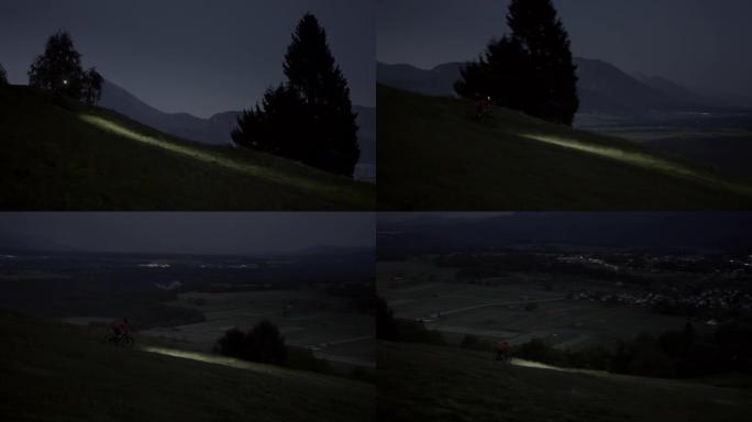 一个骑自行车的人晚上骑着MTB电动自行车下山的惊人照片。戴头灯看大自然。