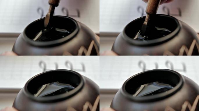 放置在黑色墨水瓶中的木制钢笔笔尖的特写
