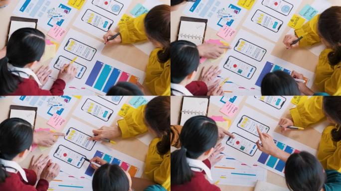 关闭顶部视图亚洲ux开发人员和ui设计师手头脑风暴关于现代办公室表格颜色代码的移动应用界面线框设计。
