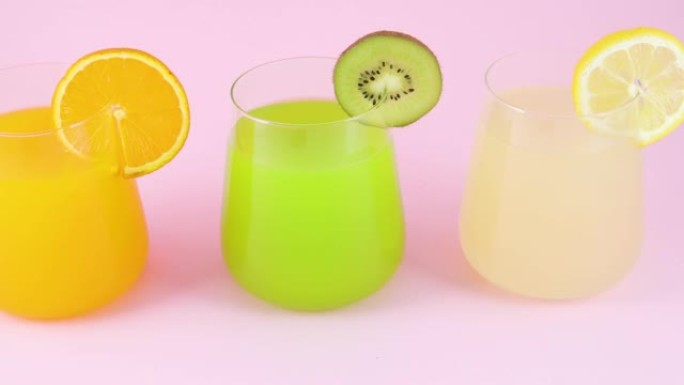 三杯各种果汁。装有橙子，柠檬和猕猴桃汁的水杯