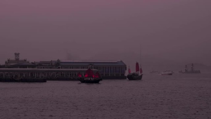 红色的Aqua Luna船在紫色的黄昏中离开香港中环天星码头