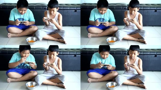 两兄弟使用智能手机玩游戏。