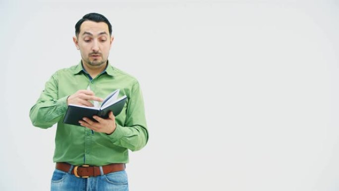 一个男人站在那里，检查着笔记本上的数据，叹气，看起来很疲倦，然后愤怒地撕下一张纸，把书扔到地板上。