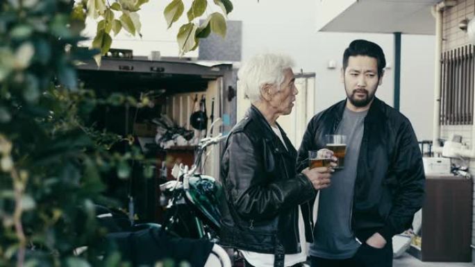 父子俩在摩托车修理厂前喝啤酒