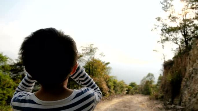 小男孩在森林里用望远镜看风景