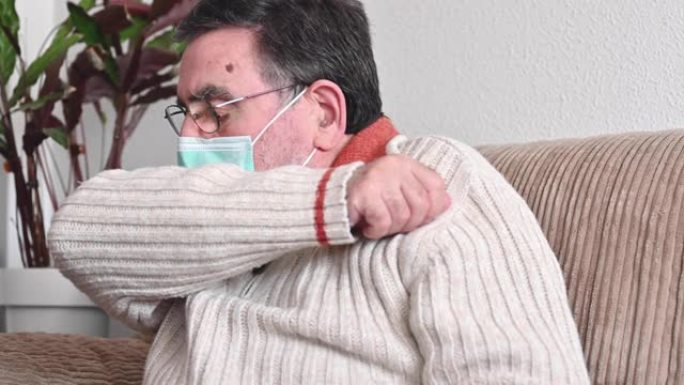 有冠状病毒症状的老人咳嗽到她的袖子或肘部，以防止传播新型冠状病毒肺炎。电晕病毒，生病的老人戴着防护口
