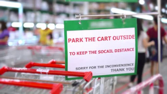 信息在外面的购物车上签名，以便在新型冠状病毒肺炎大流行期间在超市保持社交距离。