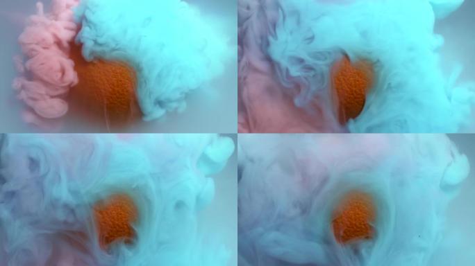 在水中混合蓝色和粉红色油漆的慢动作，在浑浊液体中向橙色水果飞溅和挥动，作为抽象流体水下背景