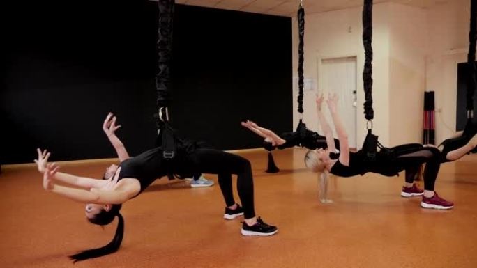 一群年轻女孩在健身房从事蹦极健身。积极运动。