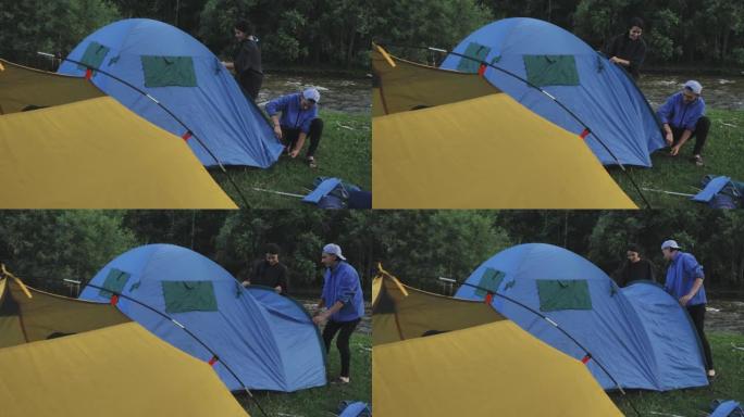 年轻夫妇在高山上扎营，搭起帐篷