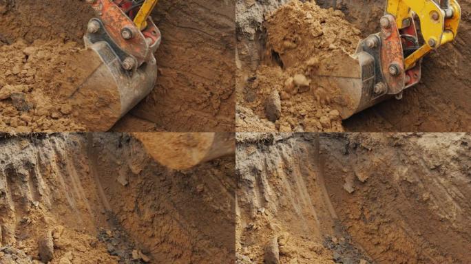 建筑工地的挖掘工作。挖掘机铲斗铲起地面并抬起