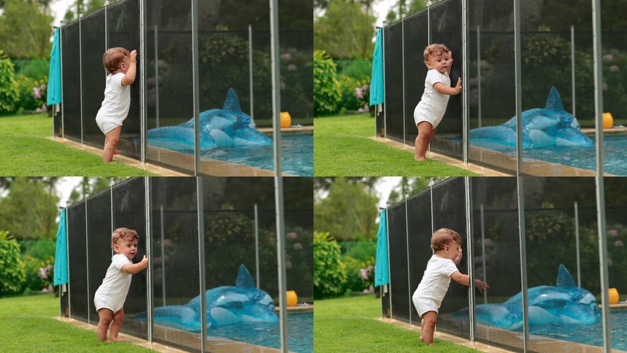 婴儿想进入游泳池水中，被安全围栏保护，防止溺水