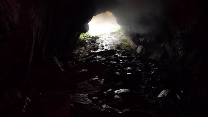 从入口处有岩石小路和日光的洞穴内观看。库存镜头。未知的地下隧道，危险的旅行概念。