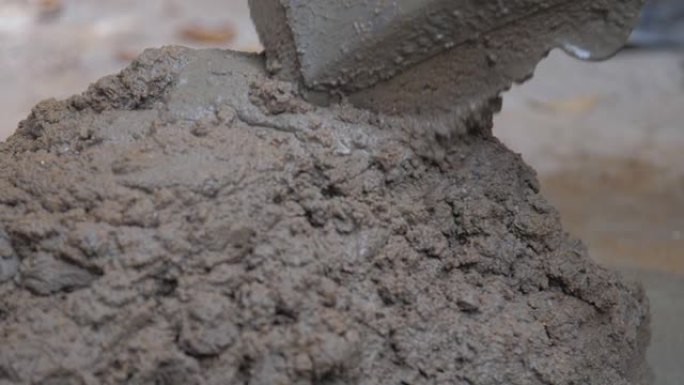 建筑工人混合湿灰水泥持铲