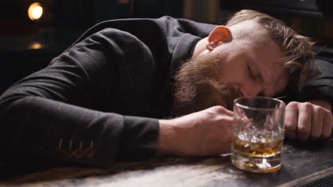 醉汉在酒吧喝杯威士忌睡着了