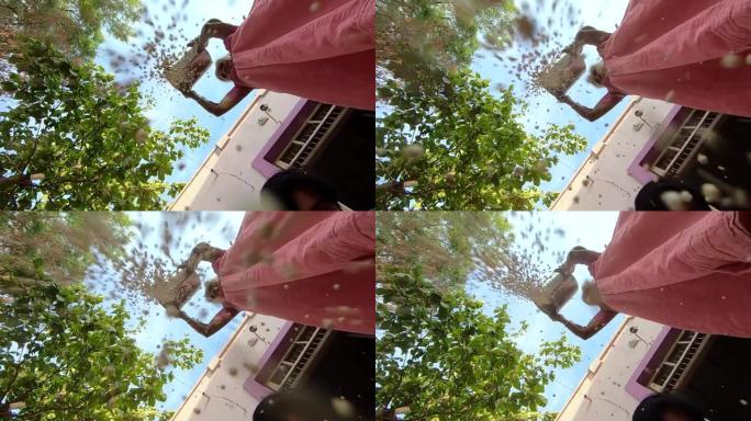 一位印度老太太向相机投掷谷物的慢动作镜头