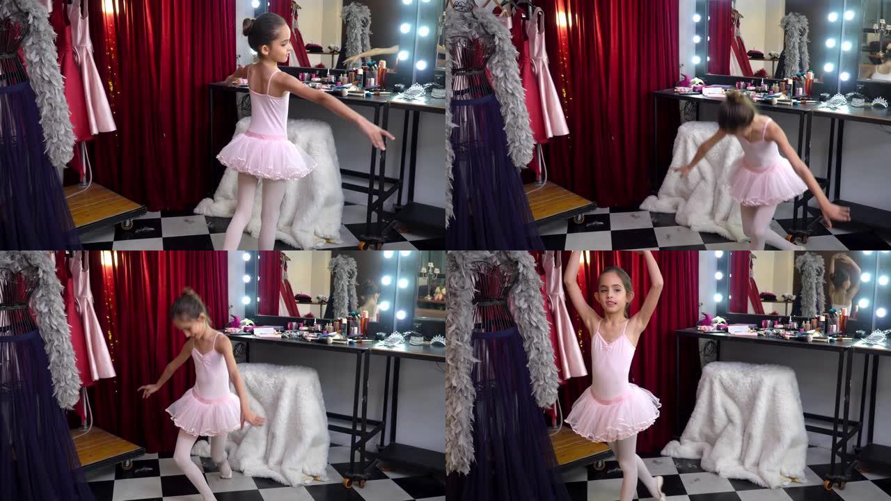 4k年轻漂亮的小芭蕾舞女舞者穿着粉色芭蕾舞裙在更衣室做舞蹈练习。穿着舞蹈服装微笑可爱的小女孩享受在化