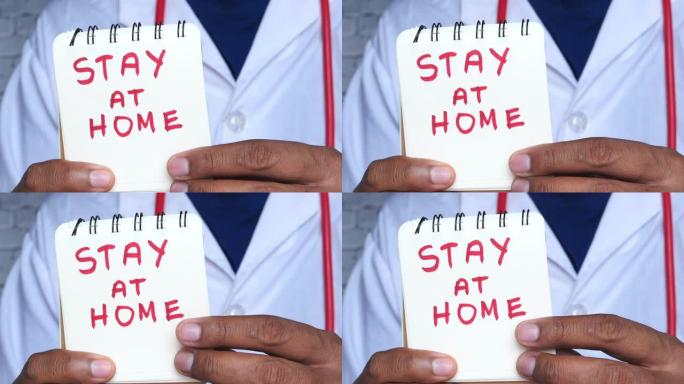 医生的手握着记事本，上面写着 “待在家里”