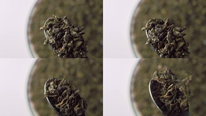 绿茶火药。在金属勺子中干燥的卷叶特写