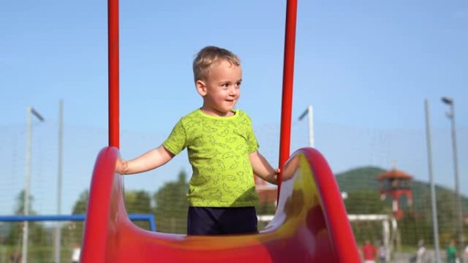 小男孩在幻灯片上玩耍