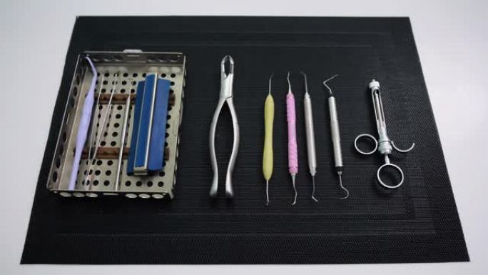 黑色垫子上牙医工具的静态照片。牙齿保健，牙齿健康概念