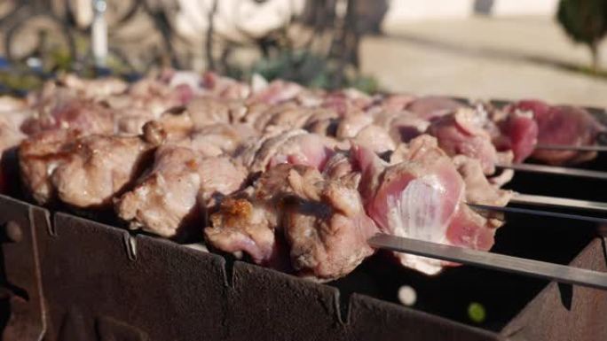 在外面的火盆上煮牛肉烤肉串。户外明火烧烤的特写烤肉串。在后院的晚宴上，在金属串上烧烤猪肉。