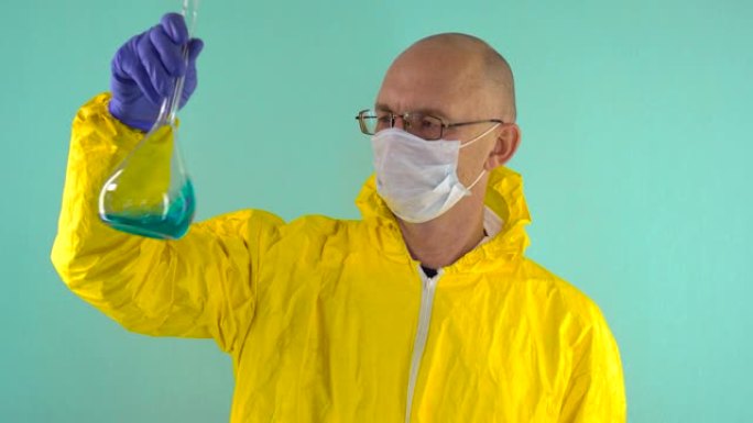 一位穿着黄色防护服，防护医用口罩和眼镜的化学科学家在蓝色背景下研究了烧瓶中的蓝色液体。科学家眨眨眼。