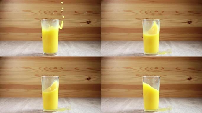 冰块滴在装有橙汁的玻璃杯中。慢动作