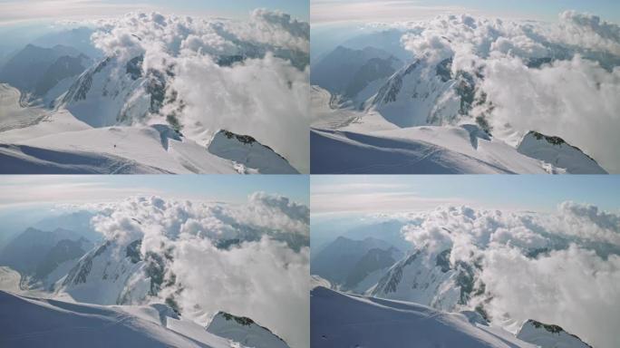 史诗般的魔云漂浮在雪顶下，登山者登上山顶