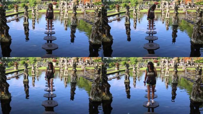 一名年轻女性游客参观印度尼西亚巴厘岛前皇宫Tirta Gangga水宫的慢镜头