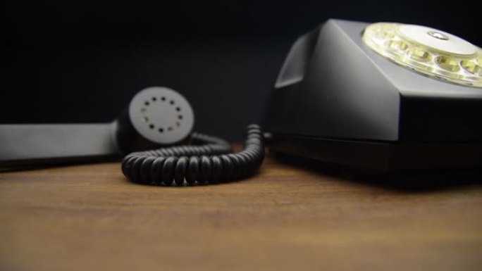 木制桌子上的复古黑色拨号电话