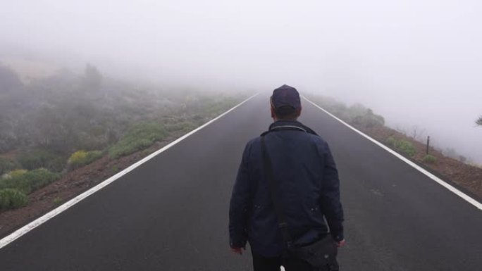 男人走在空旷而朦胧的道路中间