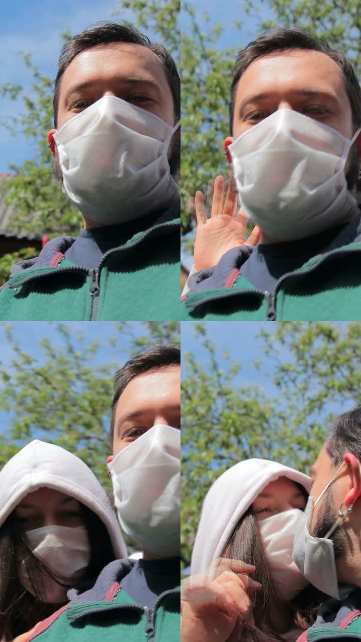戴着防护面具的夫妇的垂直手持腰部拍摄，在视频通话中进行生动的交谈。冠状病毒流行，2019-nCoV新