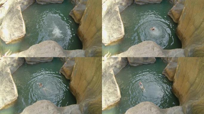 一个年轻女子从悬崖跳进河里的慢动作镜头。夏季概念