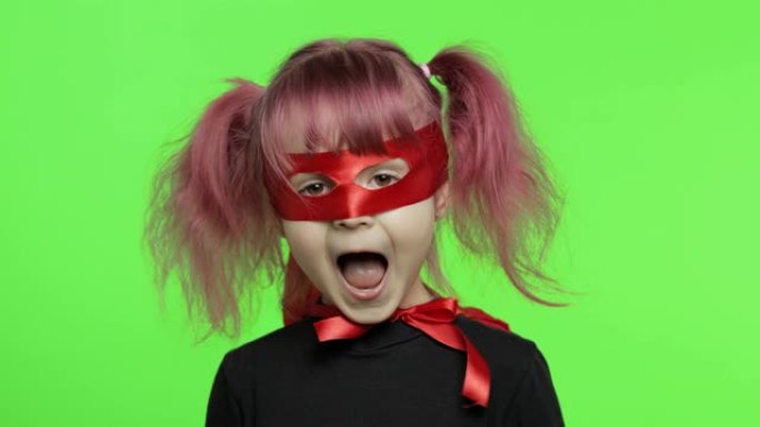 穿着服装和面具的有趣的小女孩扮演超级英雄。国家超级英雄日