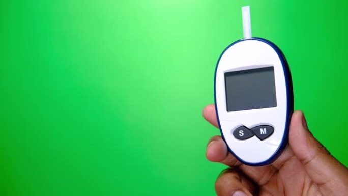 绿色背景下的人手持糖尿病测量工具