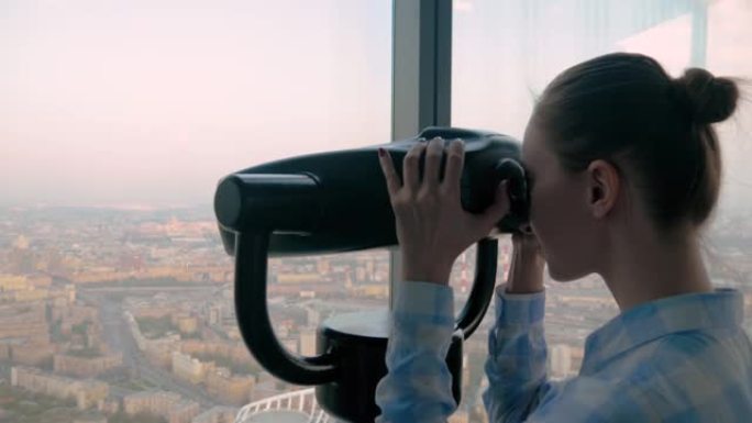 年轻女子透过旅游望远镜，探索壮观的城市景观