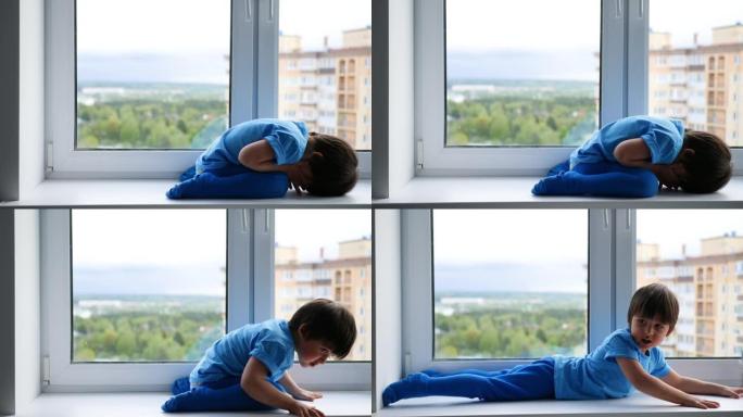 穿着蓝色t恤和紧身衣的快乐孩子坐在窗台上