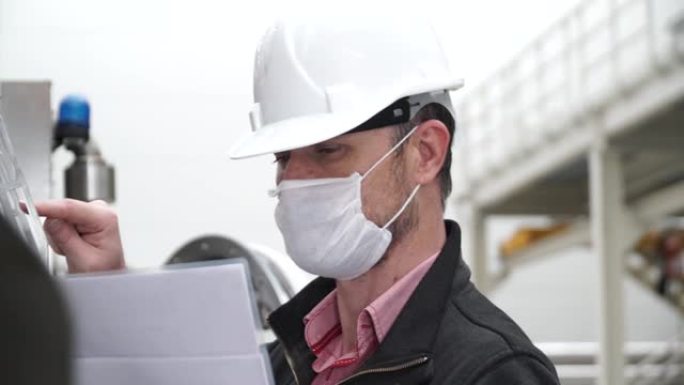 工人/工程师在工作场所或工厂工作时佩戴可保护粉尘烟雾和电晕病毒的处理面罩。