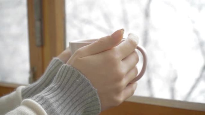 一个女孩手中的一杯芳香咖啡，冬日