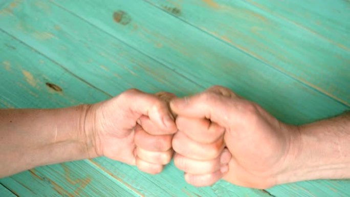 两个人的手用拳头猛击，并显示拇指向上的手势。