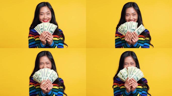 快乐的亚洲女人拿着一堆钱